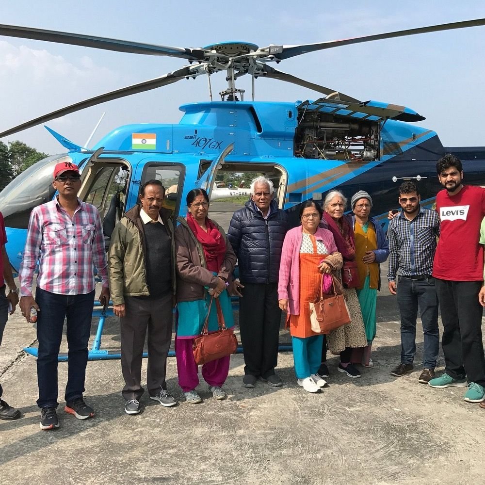 Char Dham Yatra group beside a Bell 407 helicopter
