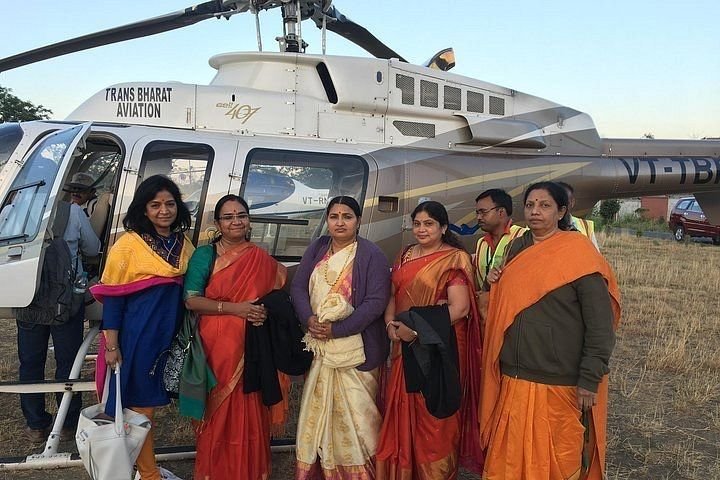 Char Dham Yatra guests beside a Trans Bharat Aviation helicopter